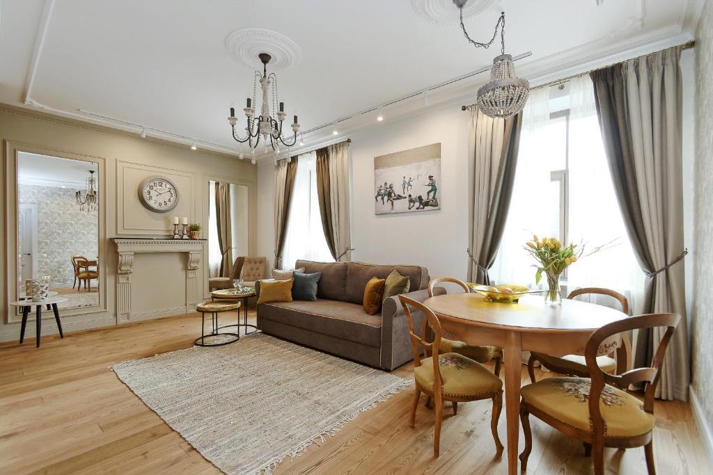 a living room with a couch and a table at Dzirnavu Residense in Riga