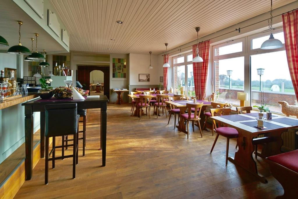 un ristorante con tavoli, sedie e finestre di Landgasthof Waabs Mühle a Waabs