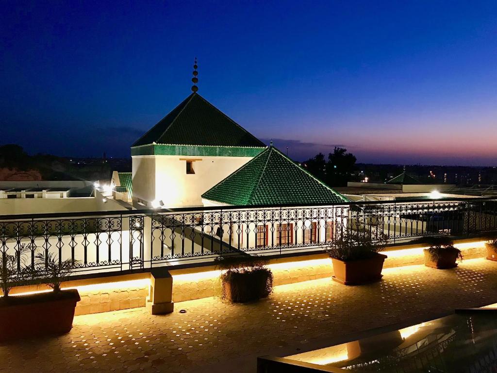 a building with a green roof at night at Riad Zidania in Meknès