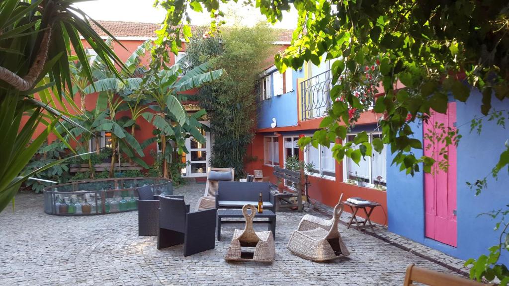 een binnenplaats met meubilair en een kleurrijk gebouw bij Casa 3 Águias in Aveiro