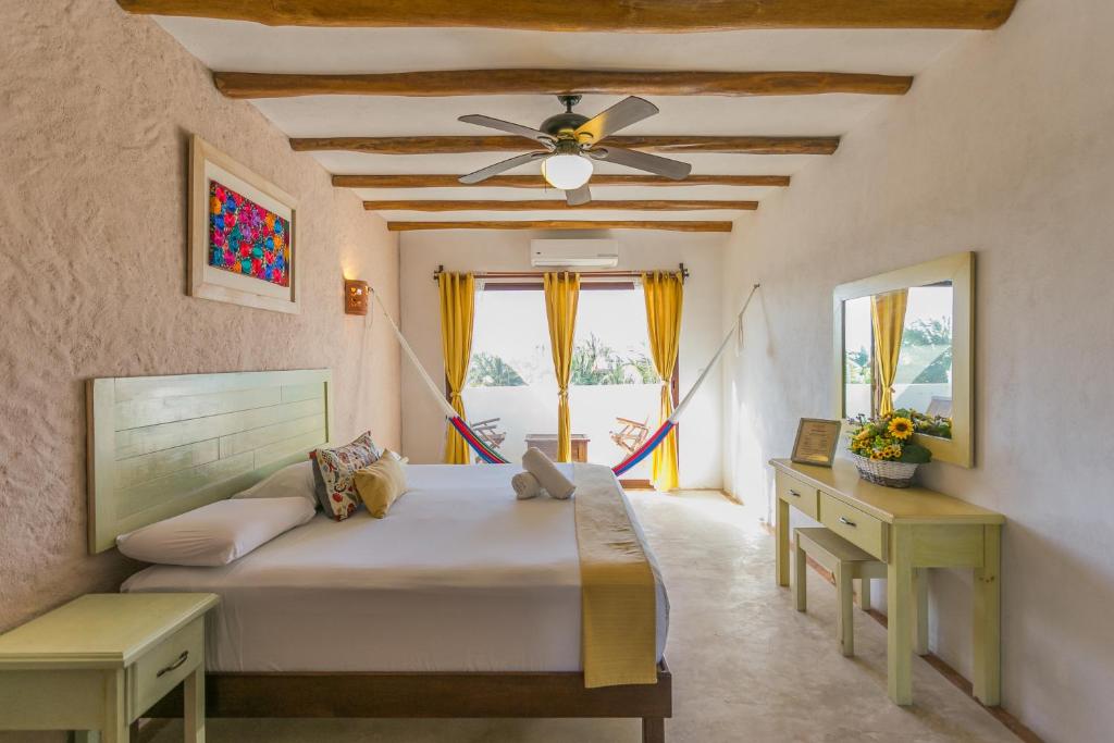 1 dormitorio con 1 cama y ventilador de techo en Villas Margaritas Holbox, en Isla Holbox