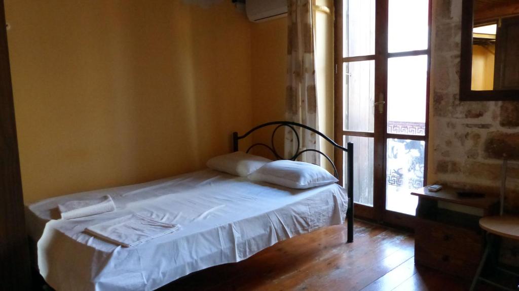 małe łóżko w pokoju z oknem w obiekcie Kydonia Rooms w Chanii