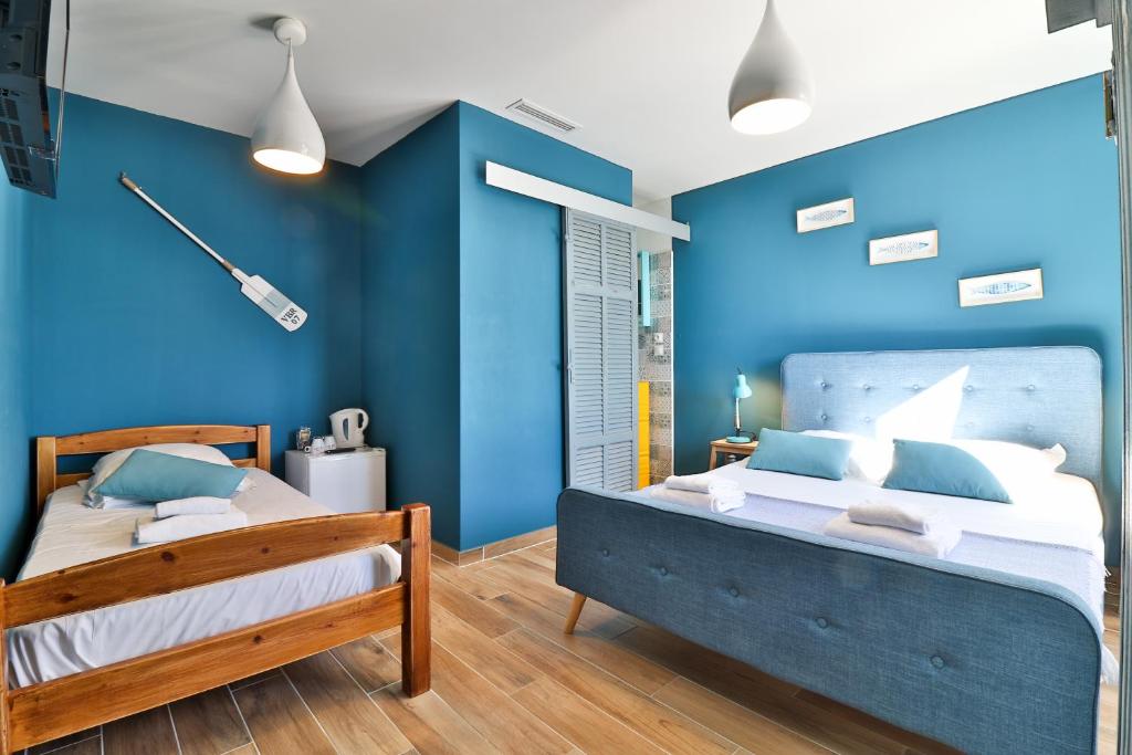 イエールにあるHôtel La Bastideの青い壁のベッドルーム1室、ベッド1台が備わります。