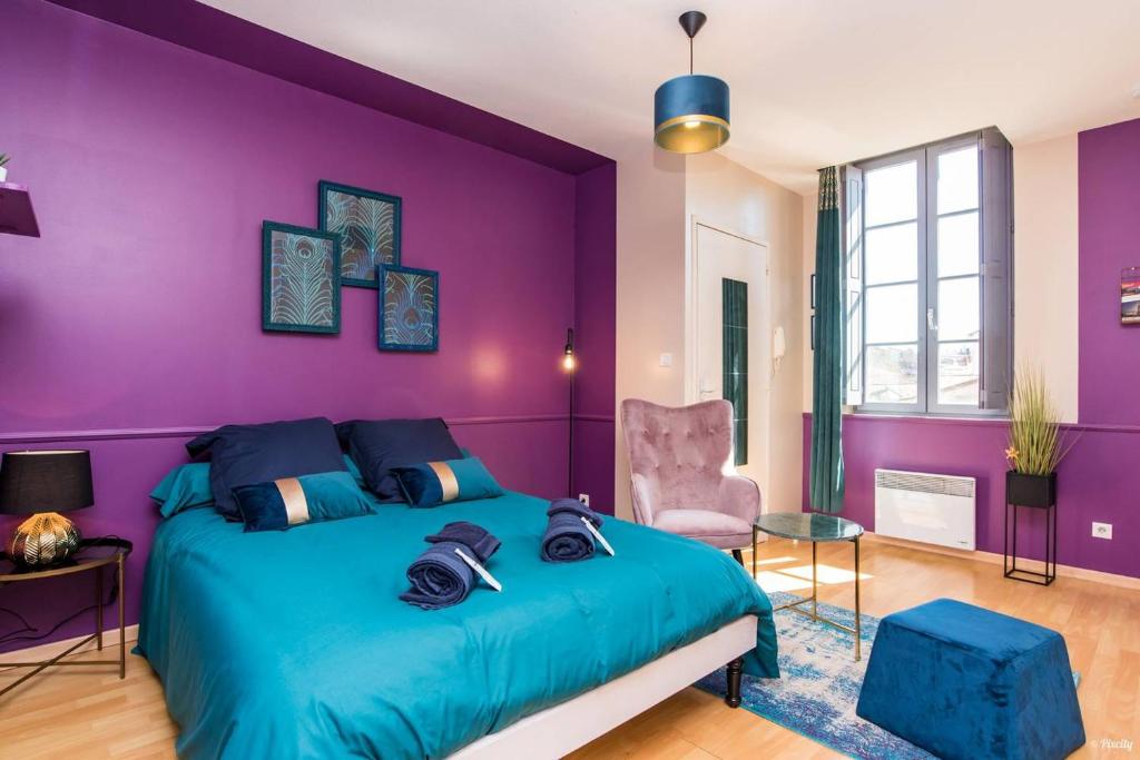 a purple bedroom with a bed and a purple wall at Appartement Le Paon in Toulouse