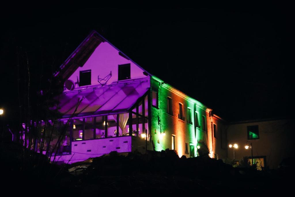 a house is lit up with purple and green lights at Hotel Feldmaus in Olzheim