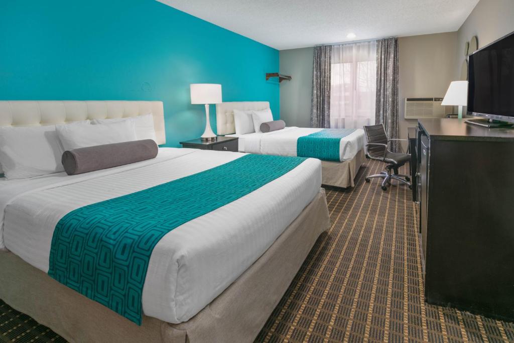 A bed or beds in a room at Howard Johnson by Wyndham Near Schlitterbahn