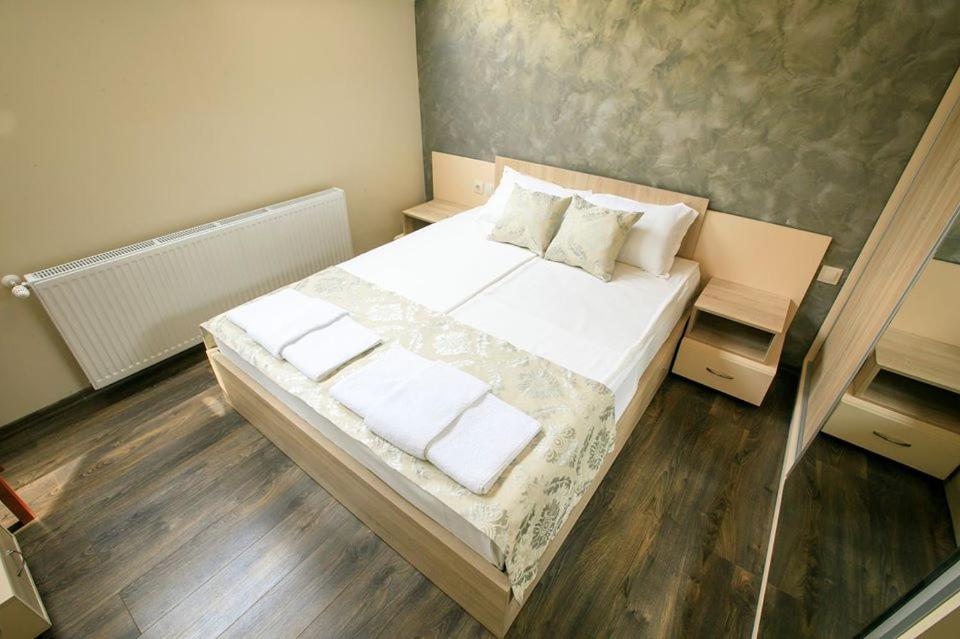 - une chambre avec un lit doté de draps et d'oreillers blancs dans l'établissement Апартамент Радост Сандански, à Sandanski