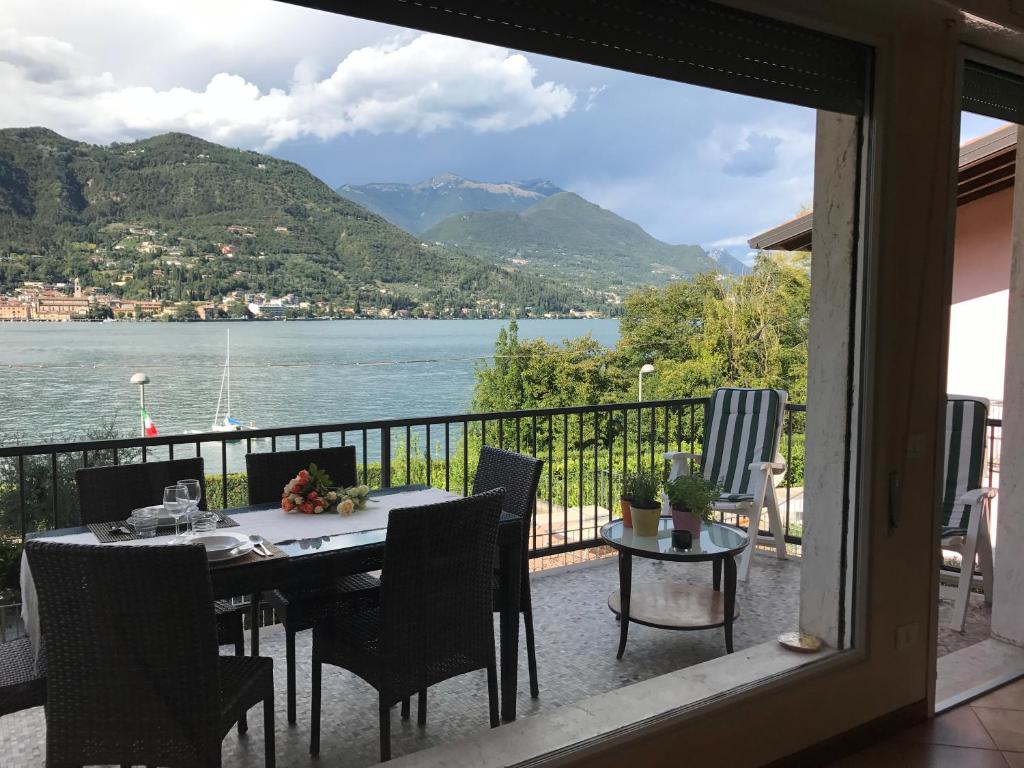 einen Tisch auf einem Balkon mit Blick auf das Wasser in der Unterkunft Holiday House Ambra in San Felice del Benaco
