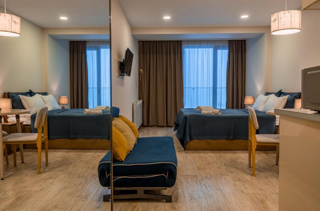 um quarto de hotel com duas camas e uma mesa em Nino's Rooms em Gudauri