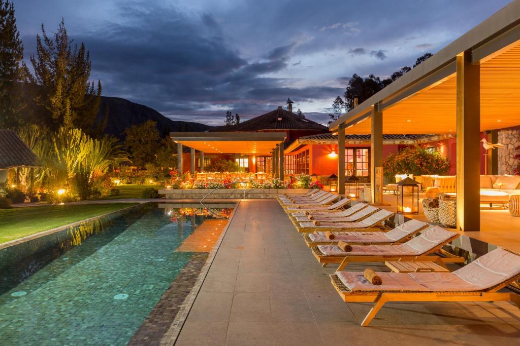 a row of lounge chairs next to a swimming pool at Sol y Luna - Relais & Chateaux in Urubamba