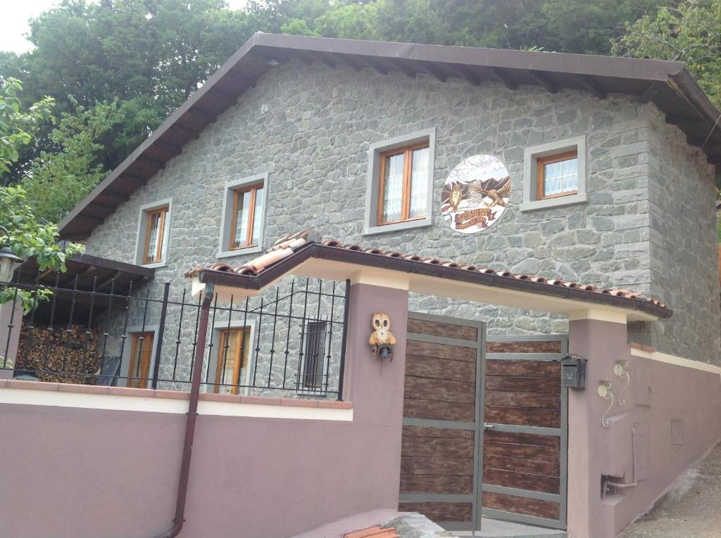 a stone house with a gate in front of it at Castel Di Gufi in Comano