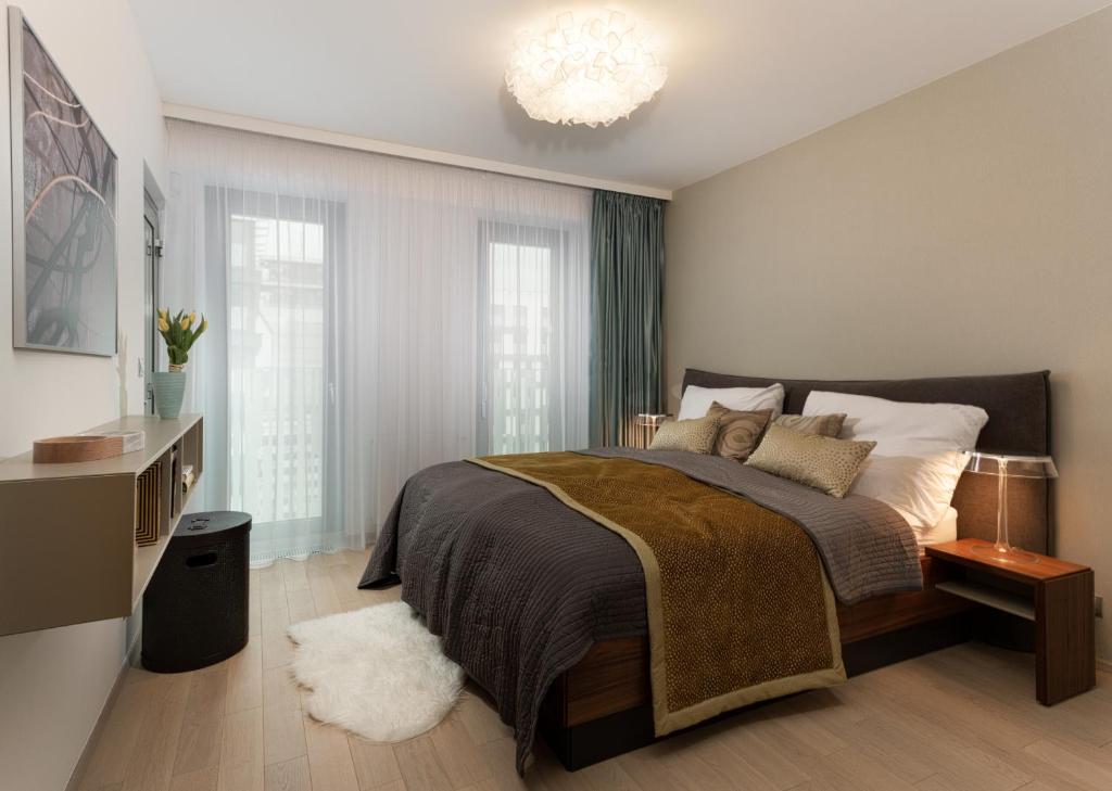 Un dormitorio con una cama grande y una lámpara de araña. en Luxurious Apartments at Žižkov, en Praga