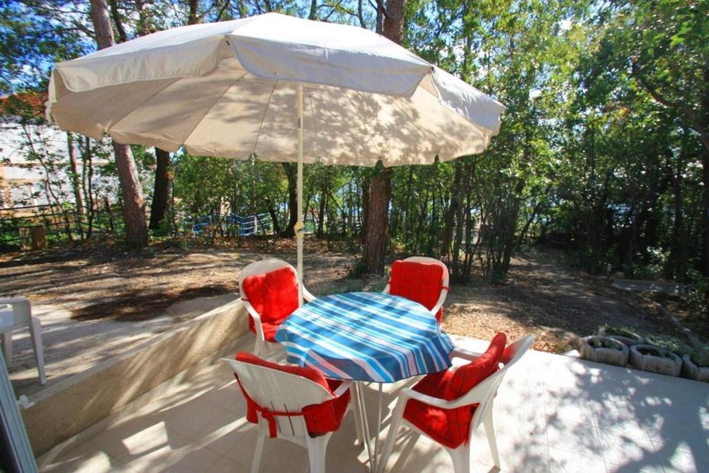 a table and chairs under an umbrella on a patio at Crikvenica Apartment 24 in Dramalj