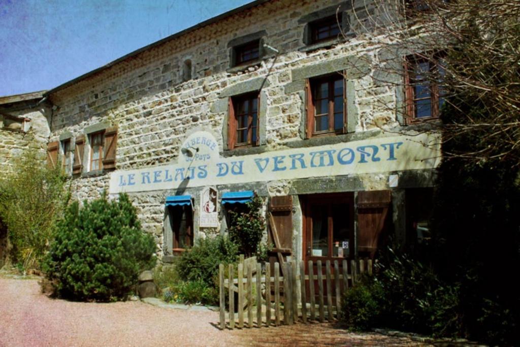 an old brick building with a sign on it at Le Relais du Vermont in Baffie