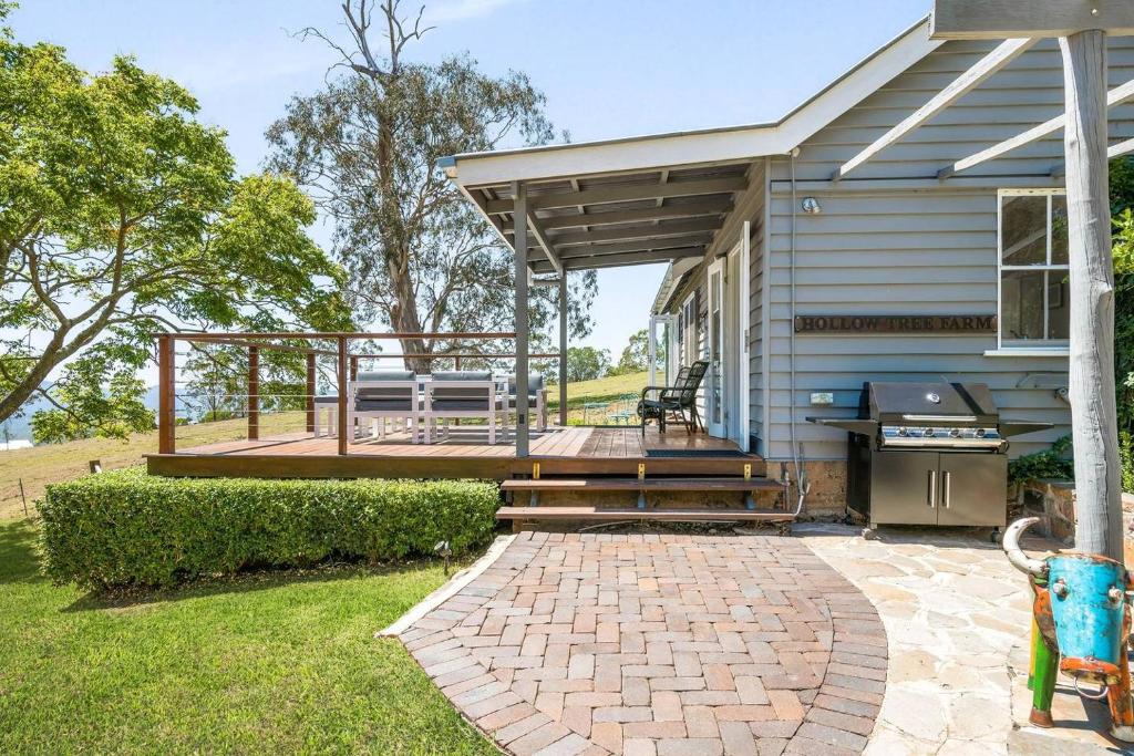 a house with a deck with a grill and a patio at Hollow Tree Farm in Toowoomba