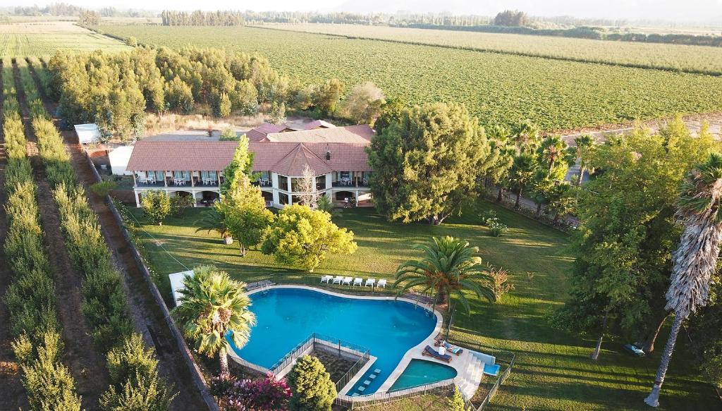 an aerial view of a house with a swimming pool and a field at La Perla Hotel in Santa Cruz