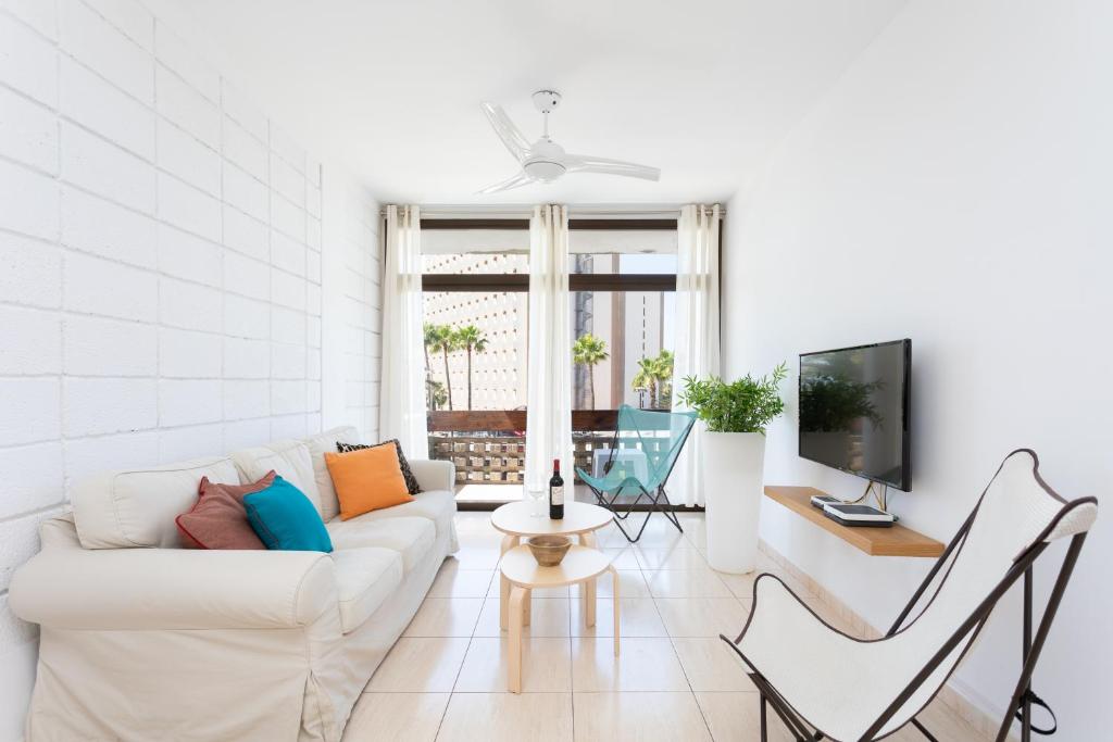 uma sala de estar branca com um sofá branco e cadeiras em Las Américas Downtown : Prime location accomm. em Arona