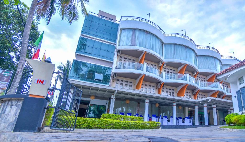 a large building with a palm tree in front of it at Ceylon Sea Hotel in Tangalle