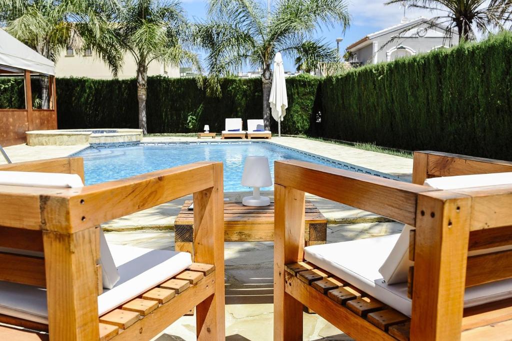 - une piscine avec 2 chaises et une table dans l'établissement Hotel La Gastrocasa - Adults Only, à Gandía