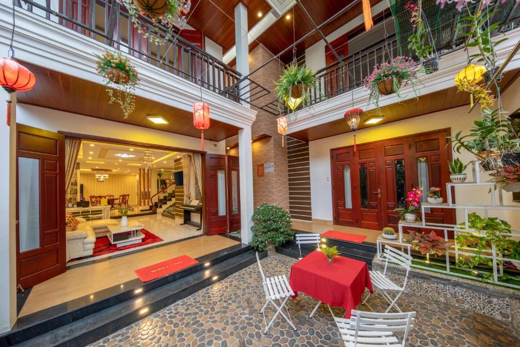 a lobby of a building with a red table and chairs at Nu Ni Homestay in Hoi An