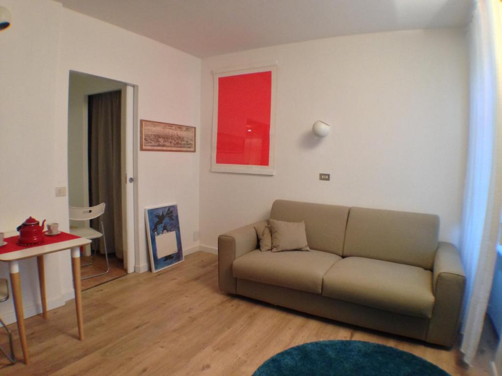 ein Wohnzimmer mit einem Sofa und einem Tisch in der Unterkunft Accogliente monolocale alla Gran Madre in Turin