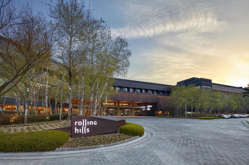 a building with a rolling hills sign in front of it at Rolling Hills Hotel in Hwaseong