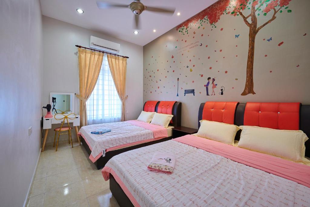 a bedroom with two beds and a tree mural on the wall at Esdi Homestay Malacca in Melaka