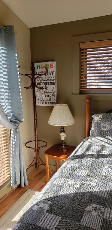 a bedroom with a bed and a table with a lamp at A Shack In The Woods in Port Renfrew