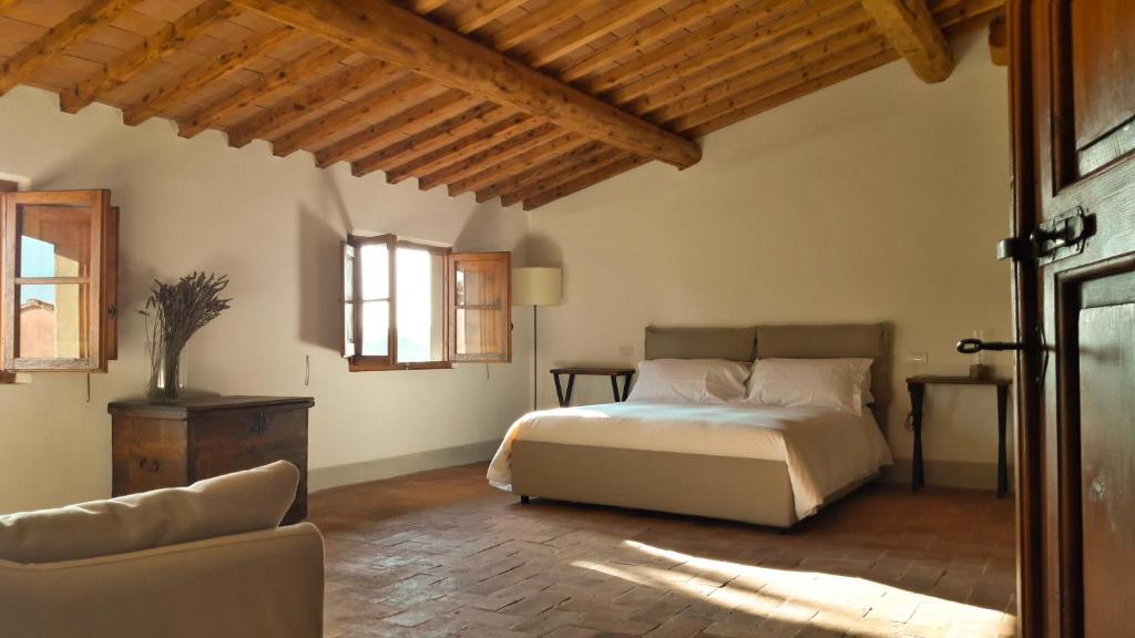 a bedroom with a bed and a couch in a room at Agriturismo Villa Gorgognano in Certaldo