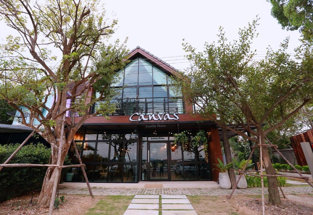 a building with a sign on the front of it at Canvas Family Home in Trat