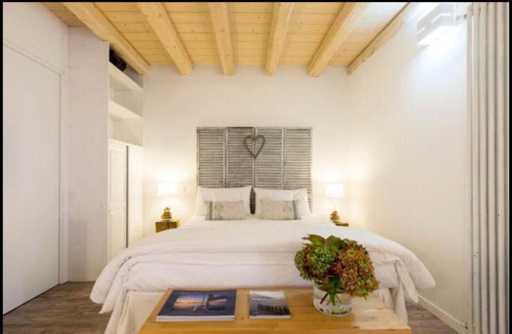 アンジェーラにあるA Casa di Ale Lago Maggiore Private outdoor saunaの白いベッドルーム(大型ベッド1台、テーブル付)