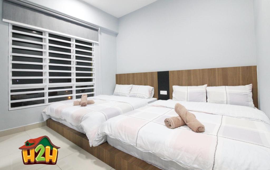 two beds in a bedroom with white sheets at H2H - TT Court Majestic Ipoh in Ipoh