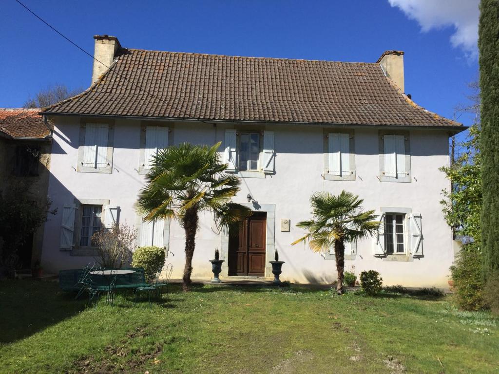 una casa bianca con due palme di fronte di berdoulet a Bétracq