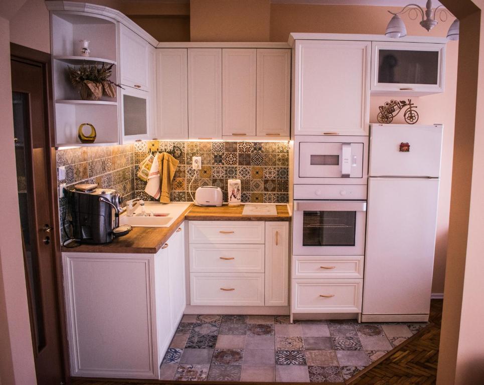 uma cozinha branca com armários e electrodomésticos brancos em Two Bedroom Apartment Downtown Ivanovi em Varna