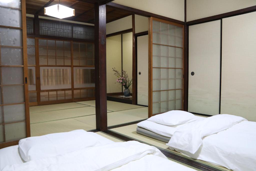 Postel nebo postele na pokoji v ubytování Guesthouse Omihachiman
