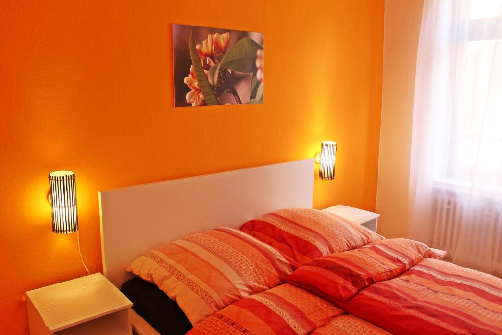 a bedroom with a bed with an orange wall at Living in the historic Cochem Old Town in Cochem