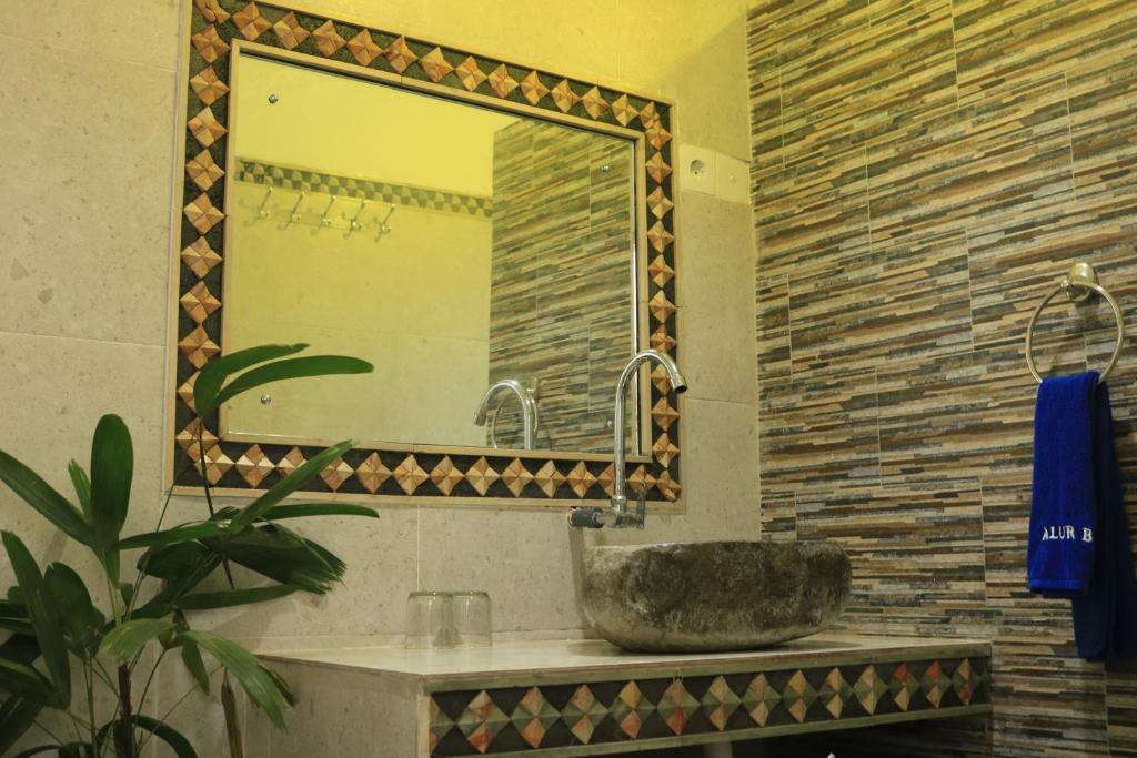 een badkamer met een wastafel en een spiegel bij Alur Beach Homestay in Amed