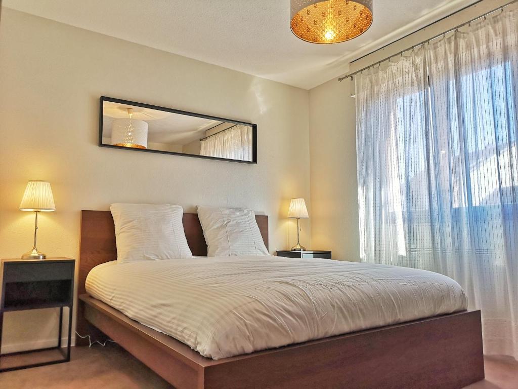 une chambre avec un lit avec un miroir et une fenêtre dans l'établissement Chez Charlie - Centre ville Colmar - 2 pièces, à Colmar