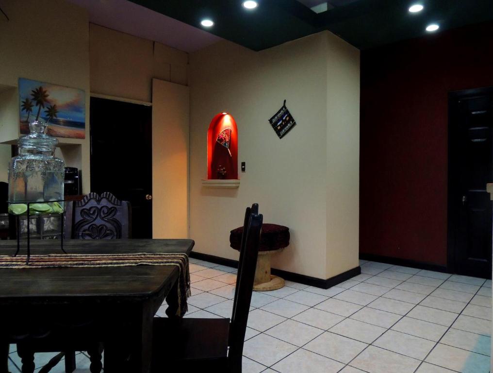 a dining room with a table and a red wall at Apartamento Central Xelajú in Quetzaltenango