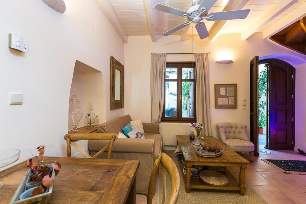 a living room with a couch and a ceiling fan at Anastasia's Venetian House in Rethymno