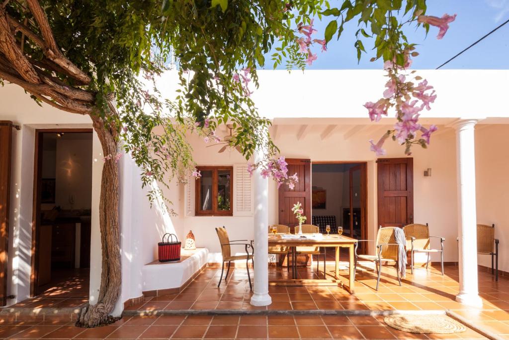 een patio met een tafel en stoelen en een boom bij can vinyeta in San Jose de sa Talaia