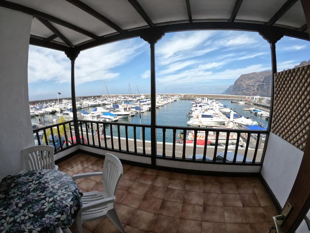 a balcony with a view of a marina with boats at Apartamento vacacional Los Gigantes in Santiago del Teide