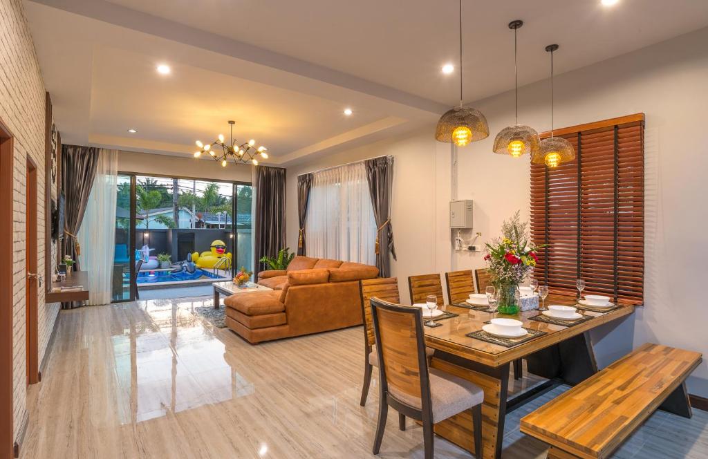 ein Esszimmer und ein Wohnzimmer mit einem Esstisch in der Unterkunft De Nathai Private Pool Villa in Ao Nang Beach