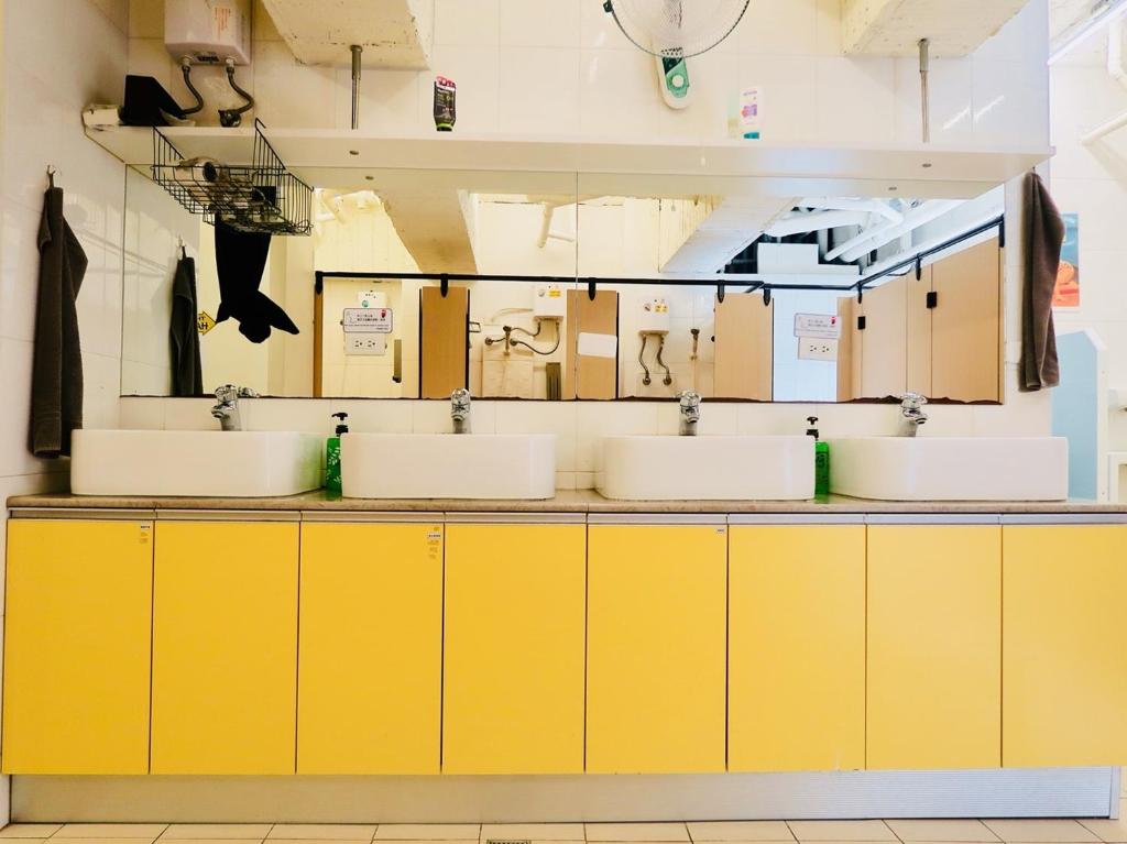 a counter with three sinks in a room at Trip GG Hostel in Kaohsiung