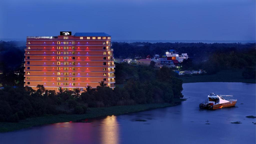 a large building with a boat in the water at JVK Park Hotel in Cochin