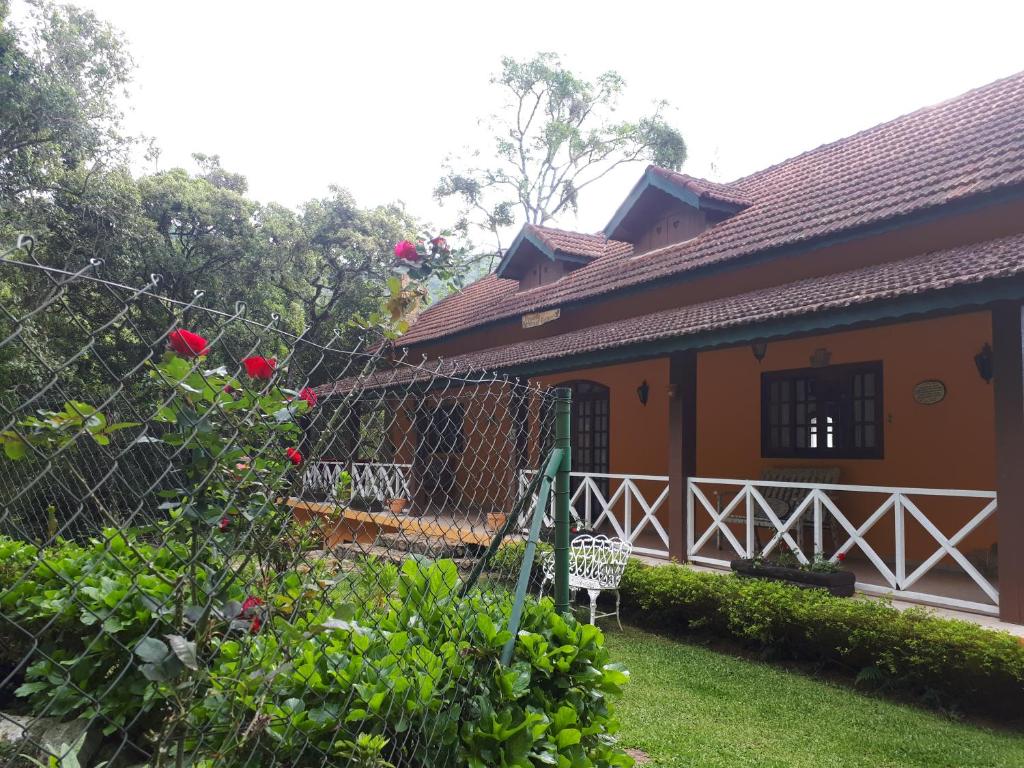 uma casa com uma cerca em frente a um quintal em RIL - Mount Everest em Monte Verde