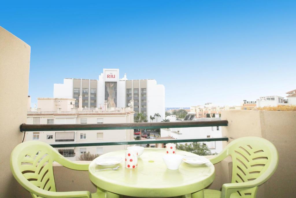 einen Tisch und Stühle auf einem Balkon mit Stadtblick in der Unterkunft Apartment Cala de Nerja SpainSunRentals 1083 in Nerja