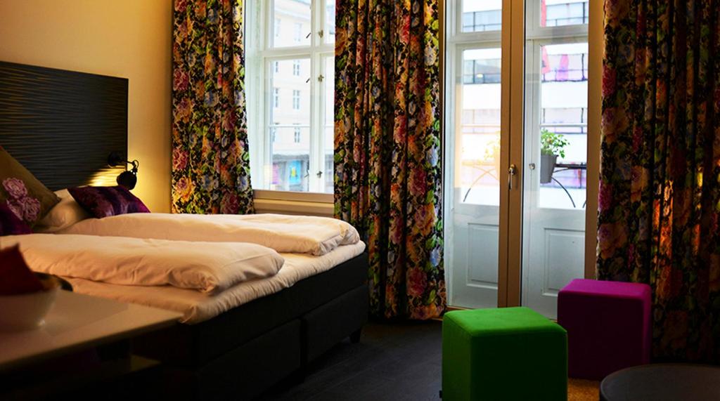 a bedroom with two beds and a window with curtains at Hotel No13 in Bergen