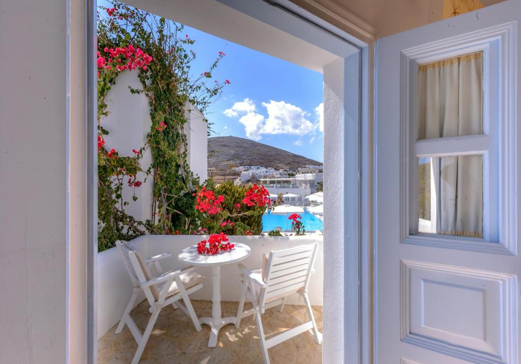 a table and chairs on a balcony with a view of the ocean at Chora Resort Hotel & Spa in Chora Folegandros