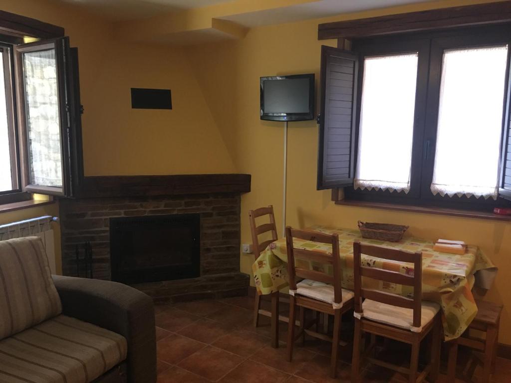 a living room with a table and a fireplace at Tía María in Cerredo